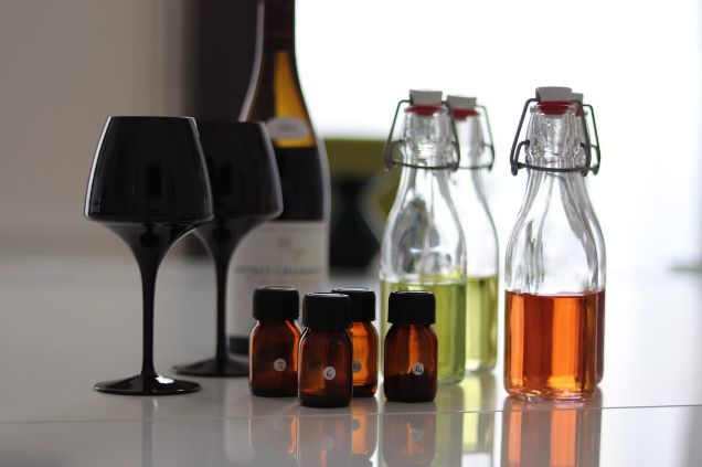 Professional at-home wine tasting setup featuring black blind-tasting glasses, aroma vials, and color samples for a Burgundy wine experience.