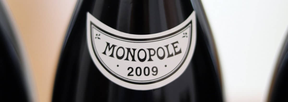 Close-up macro shot of the white Monopole 2009 neck label on a Domaine de la Romanée-Conti wine bottle
