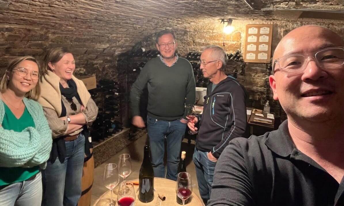 Friendly wine tasting session around a barrel with glasses of Burgundy red wine
