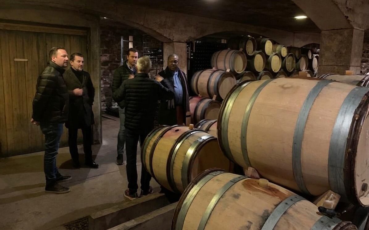 A small group of wine lovers enjoying an intimate cellar tour in Burgundy