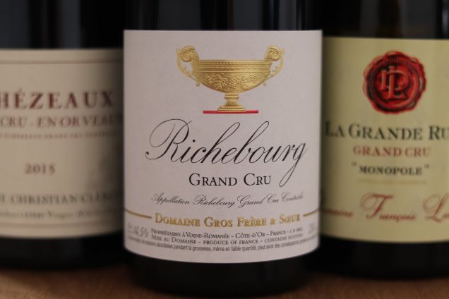 Close-up of prestigious Burgundy Grand Cru wine bottles including Richebourg and La Grande Rue Monopole for a private at-home tasting.