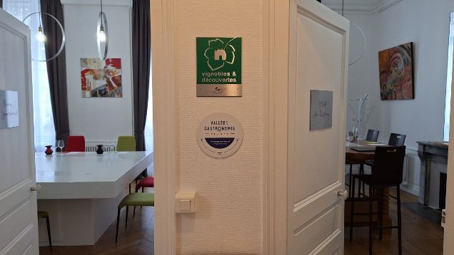 Entrance to Sensation Vin wine school in Beaune showing Vignobles & Découvertes and Vallée de la Gastronomie labels with 18th-century tasting rooms in the background.